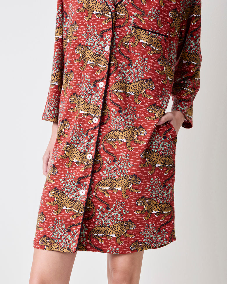 Front lower view of the Scarlet Bagheera sleep shirt showing its leopard and botanical print, buttons, black piping, hem, and side pocket.