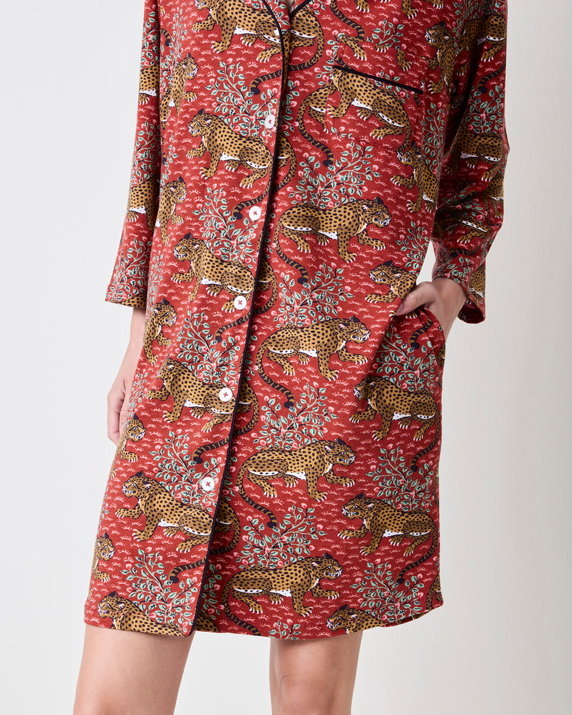 Front lower view of the Scarlet Bagheera sleep shirt showing its leopard and botanical print, buttons, black piping, hem, and side pocket.