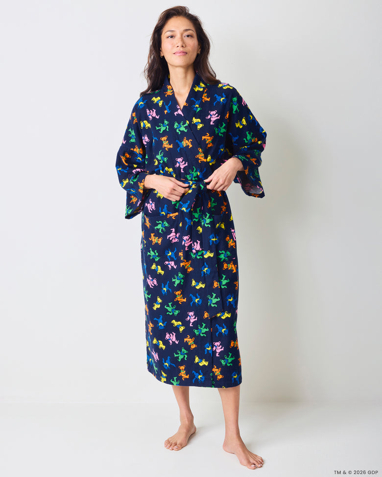Front view of a person wearing a long navy robe with a multicolor dancing-bear print and tie waist.