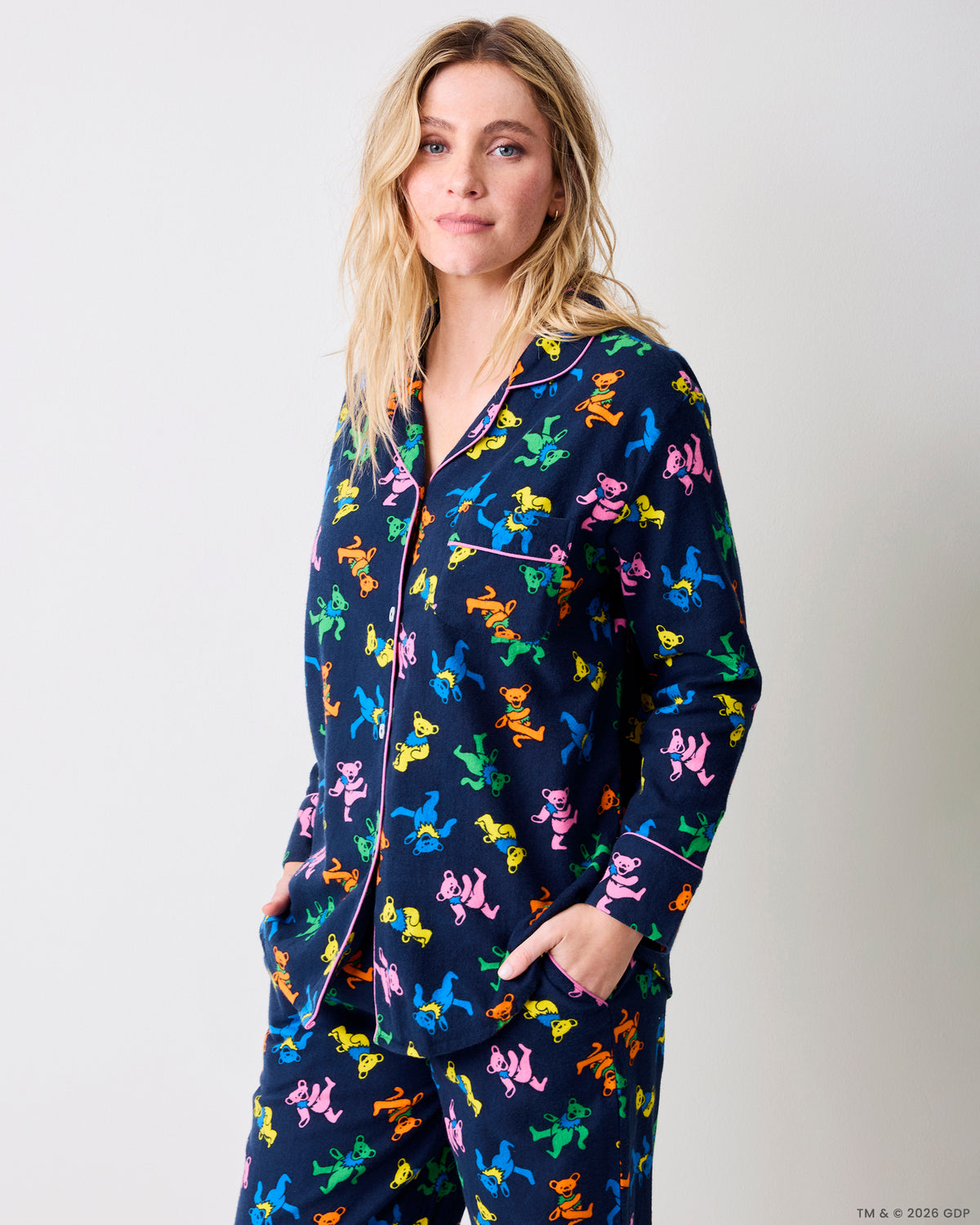 Three-quarter view of a navy Dancing Bears pajama set with colorful bear prints, pink piping, and front pockets.