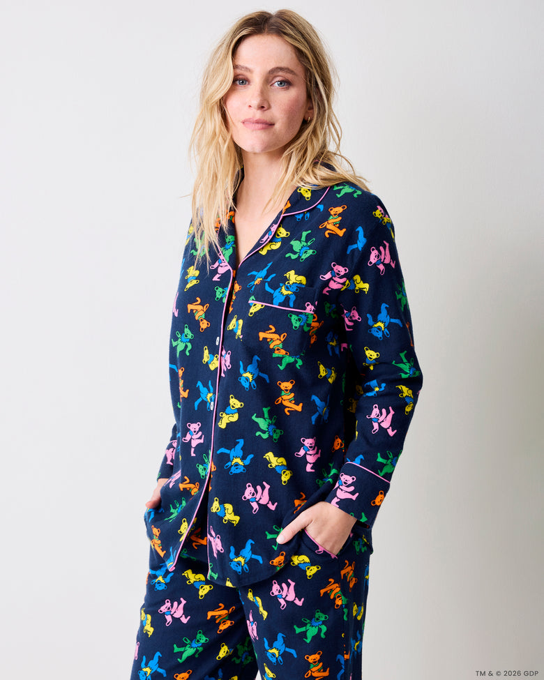 Three-quarter view of a navy Dancing Bears pajama set with colorful bear prints, pink piping, and front pockets.