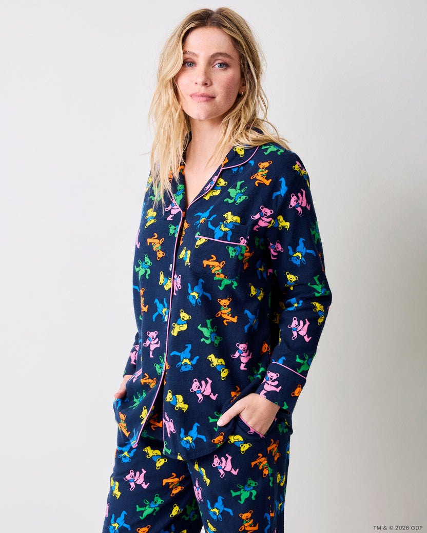 Three-quarter view of a navy Dancing Bears pajama set with colorful bear prints, pink piping, and front pockets.