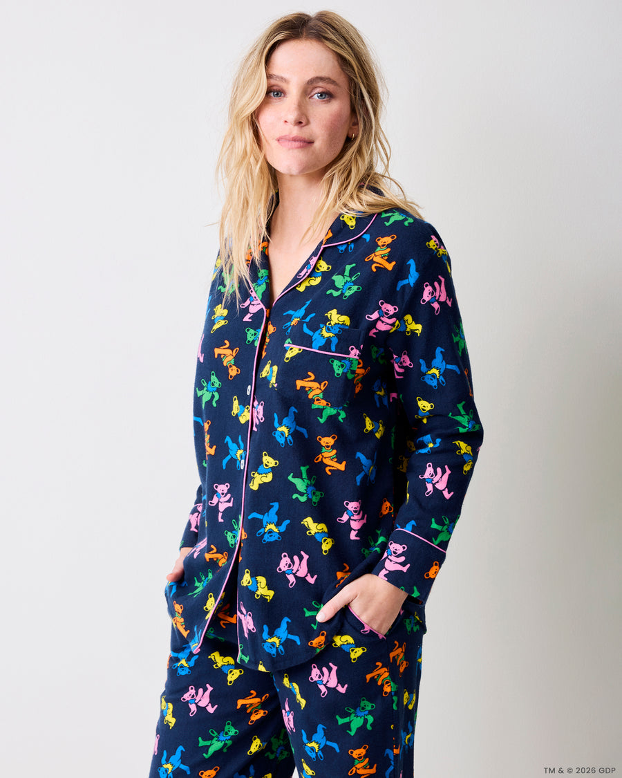 Three-quarter view of a navy Dancing Bears pajama set with colorful bear prints, pink piping, and front pockets.