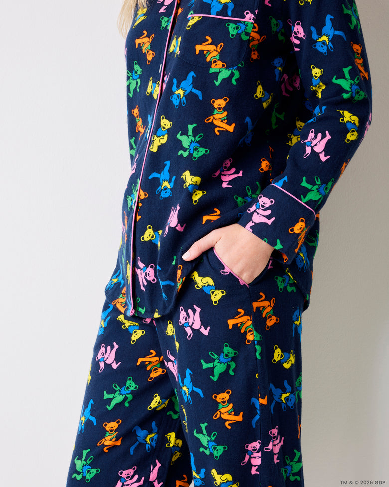 Side view of a navy Dancing Bears pajama set with colorful bear prints, shirt pockets, and pants pockets.