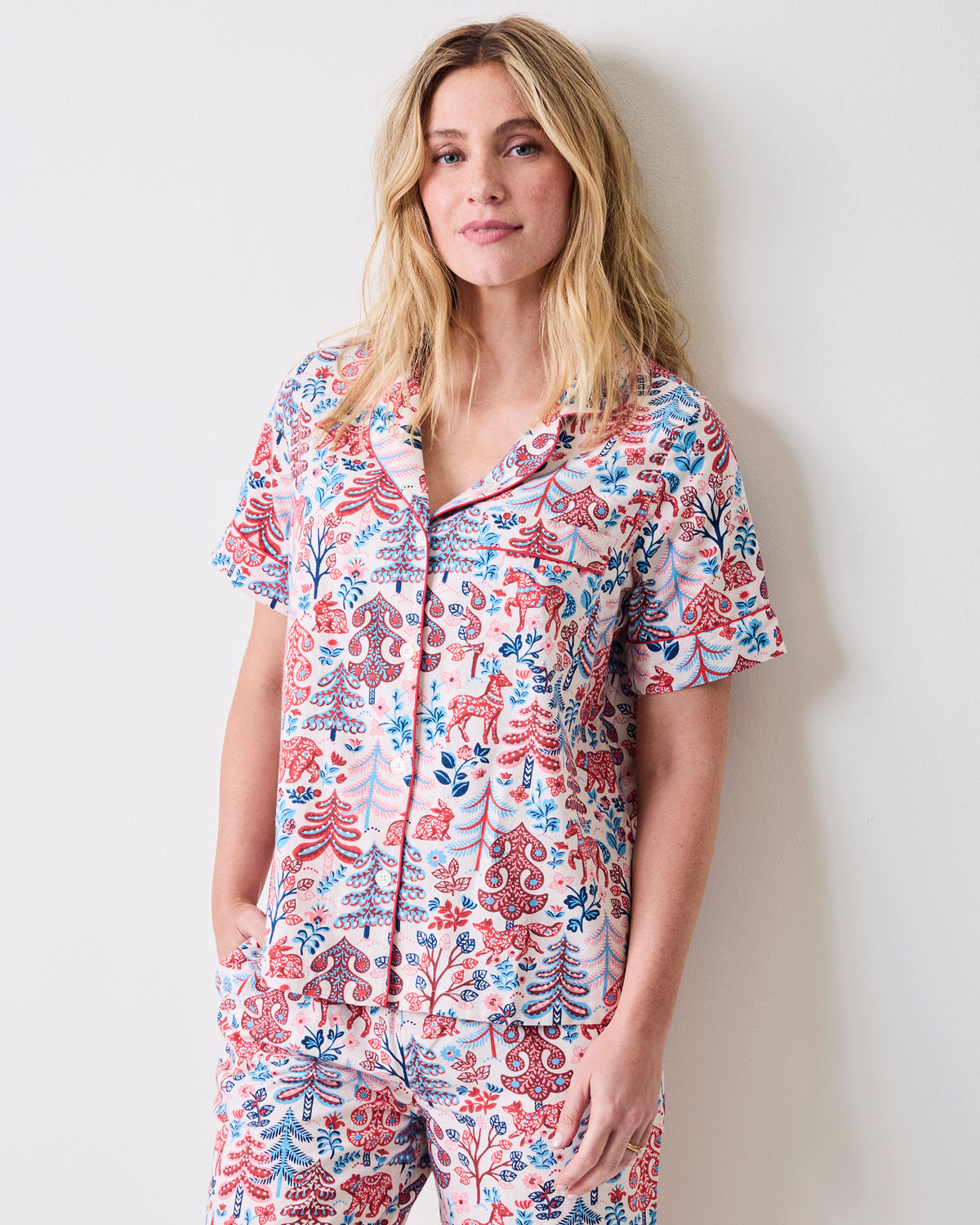 Front view of the Folklore Forest short-sleeve pajama set with a button-front top, patterned print, and cropped pants.