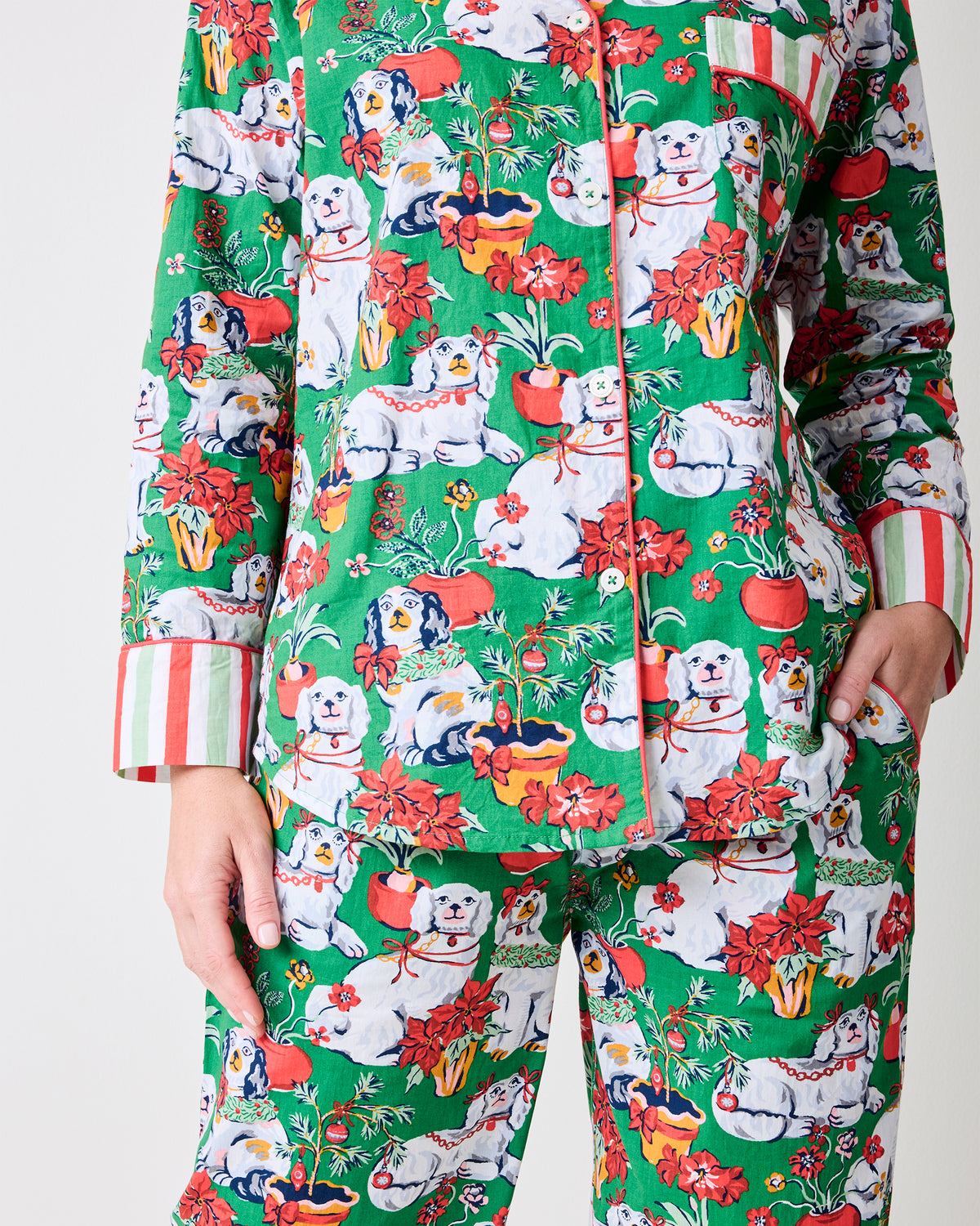 Close-up of the Good Dog Christmas evergreen tall long pajama set showing the button-front top, chest pocket, dog-and-holiday print, and striped cuffs.