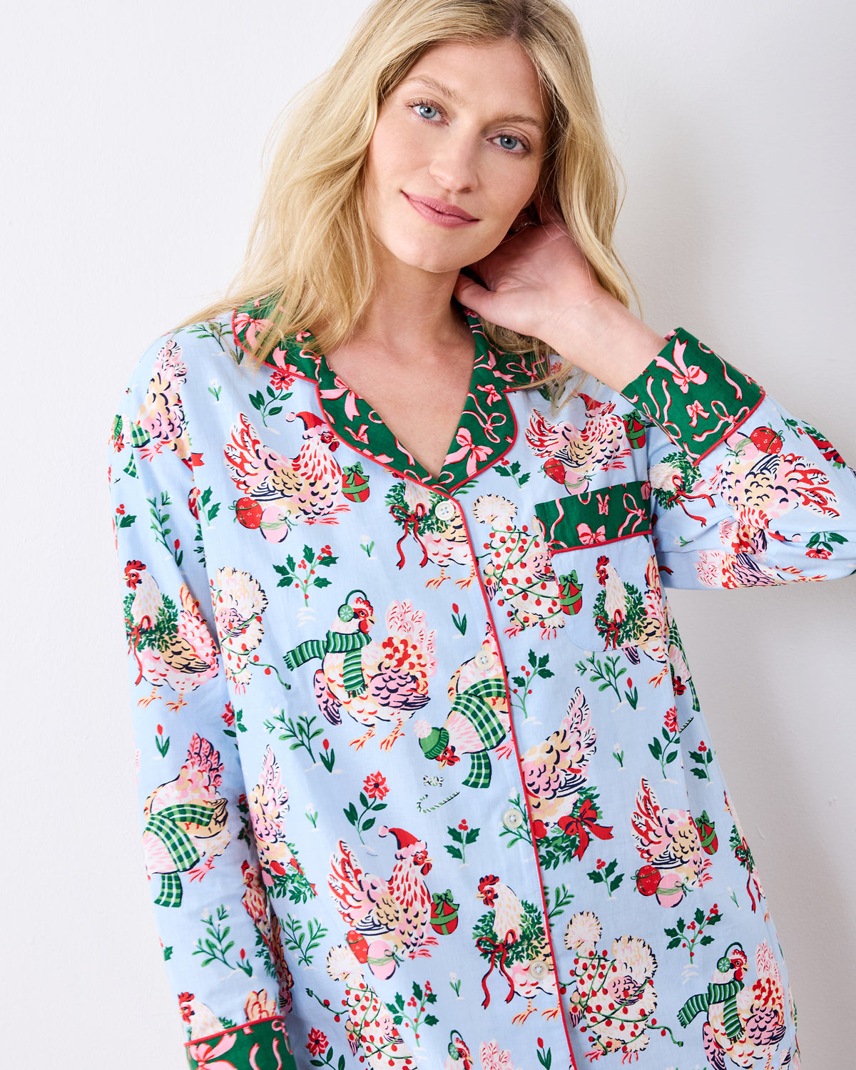 Close-up of the pale blue Holiday Hens long pajama top with a collar, button front, chest pocket, and print of hens wearing winter accessories.