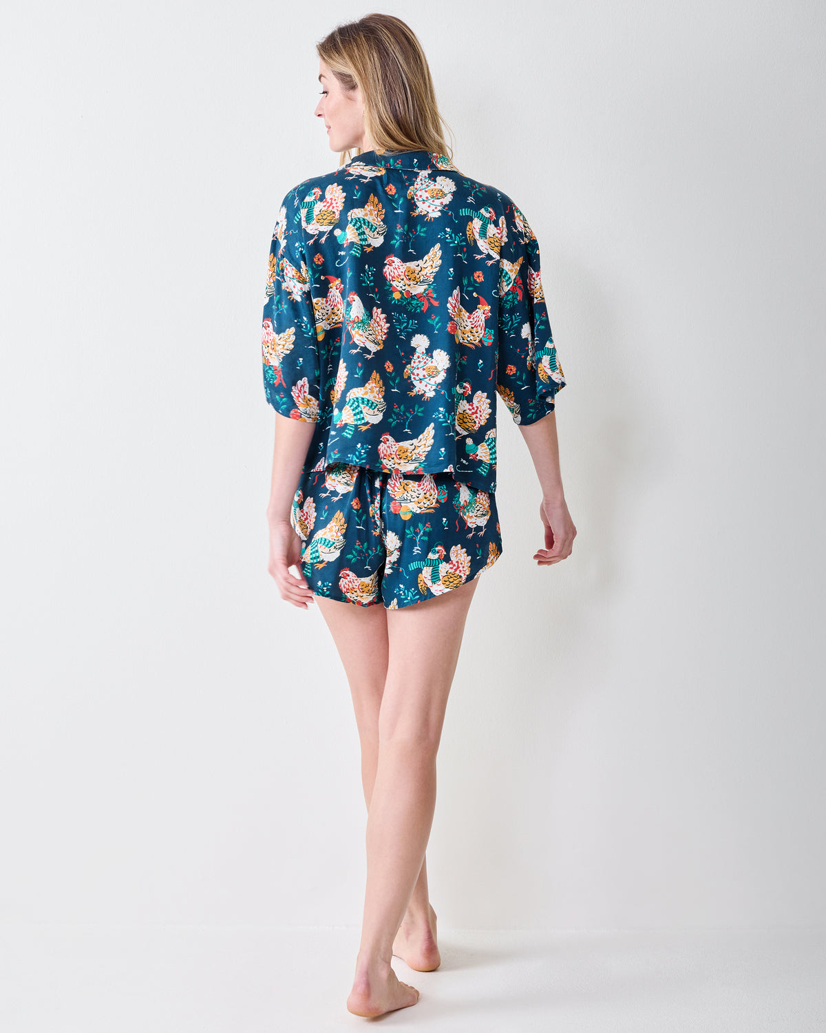 Back view of a model wearing the Holiday Hens pajama set, showing the print across the top and matching shorts.