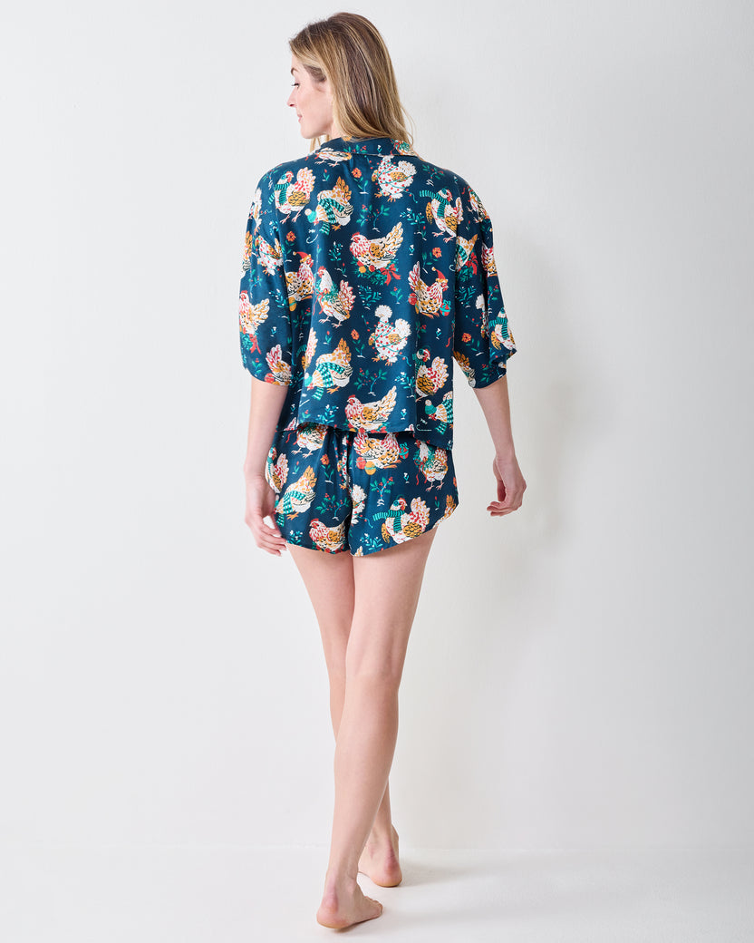 Back view of a model wearing the Holiday Hens pajama set, showing the print across the top and matching shorts.