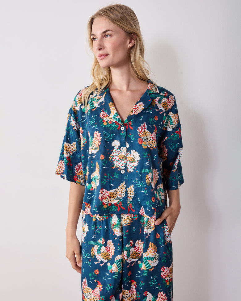 Front view of the navy Holiday Hens pajama set with a button-front top, wide-leg pants, and all-over chicken print.