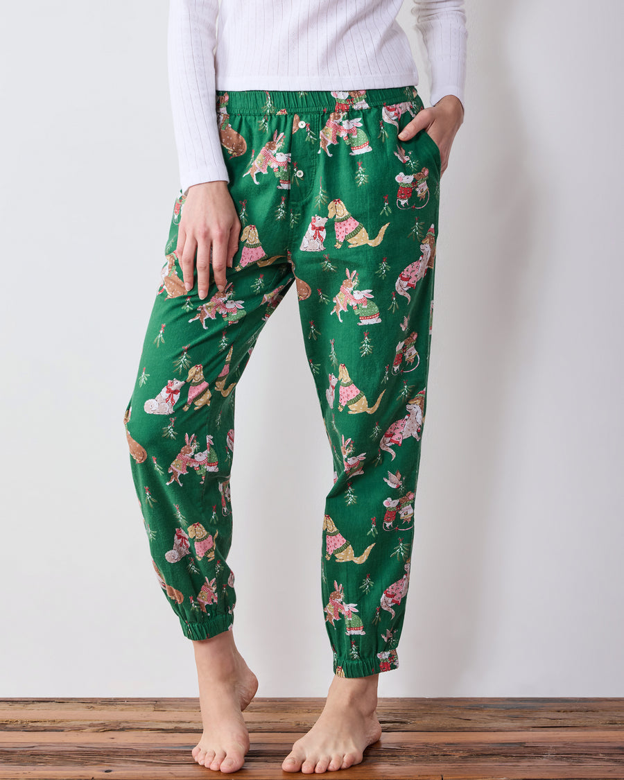 Front close-up of green printed joggers showing the elastic waistband, side pocket, relaxed legs, and gathered ankle cuffs.
