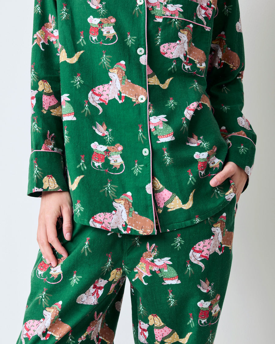 Front detail of the green Mistletoe Kiss flannel pajama set, showing the button-down top, piping, pockets, and printed pants.