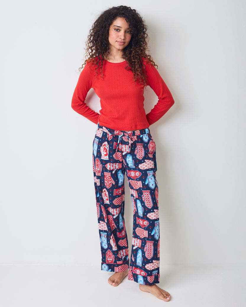 Person wearing the Viking Blue Nordic Mittens pajama pants with a red long-sleeve top.