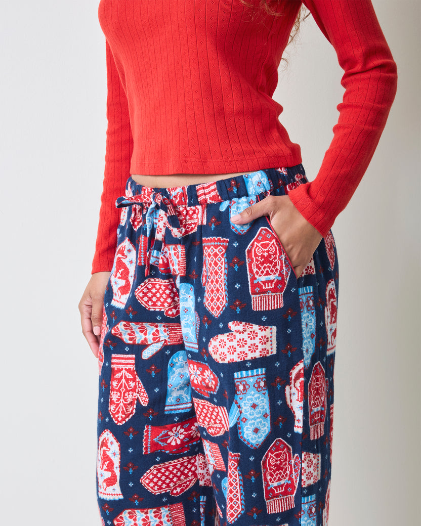 Close-up front view of blue flannel pajama pants with a mitten print, elastic waistband, drawstring, and side pocket.