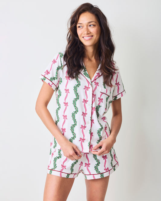 Person wearing the Ribbons & Bows Vanilla Cream short pajama set with a button-down top and shorts.