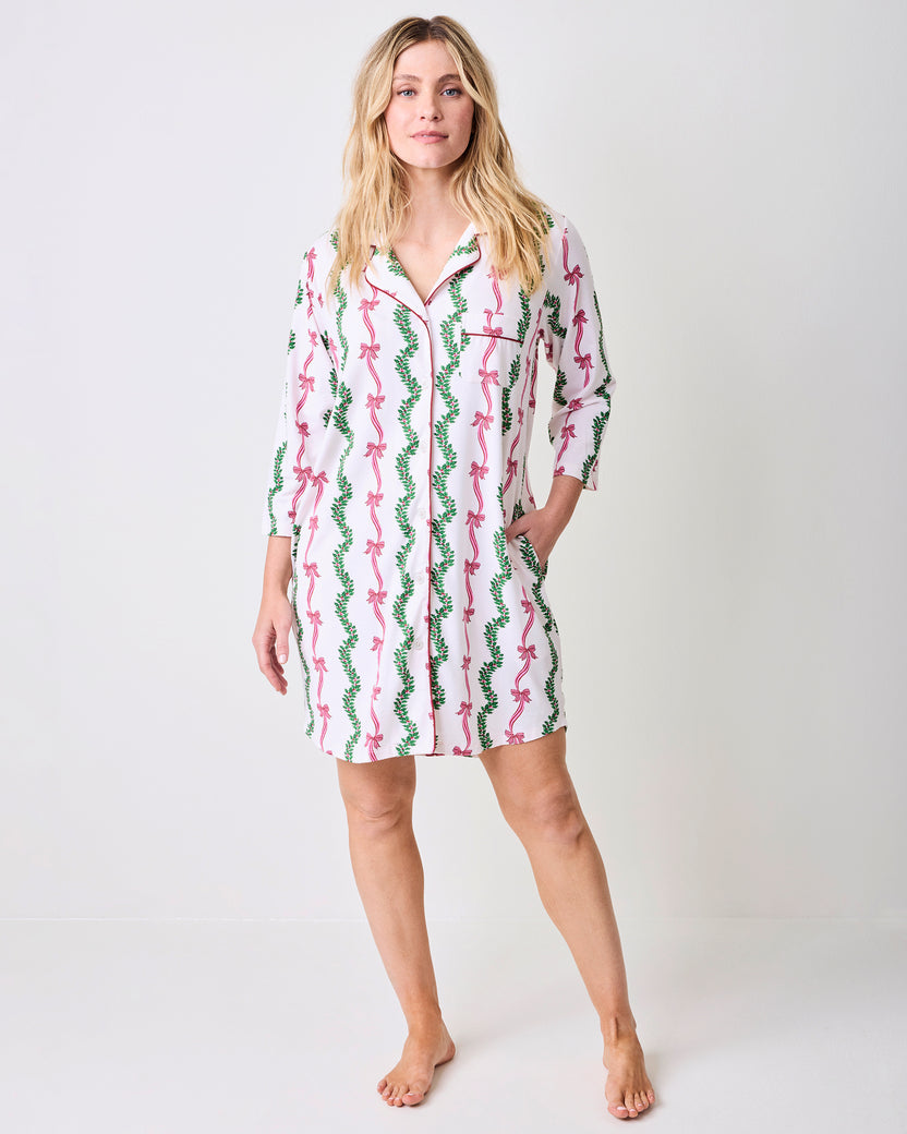 Model wearing the Ribbons & Bows sleep shirt, a button-front shirt with three-quarter sleeves and a pink bow and green garland print.