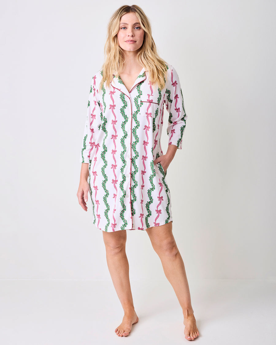 Model wearing the Ribbons & Bows sleep shirt, a button-front shirt with three-quarter sleeves and a pink bow and green garland print.