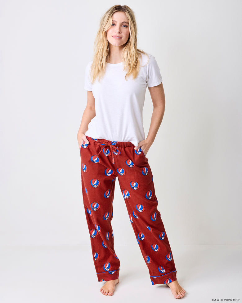 Front view of red pajama pants with a white short-sleeved shirt, showing the drawstring waist and skull-and-lightning-bolt print.