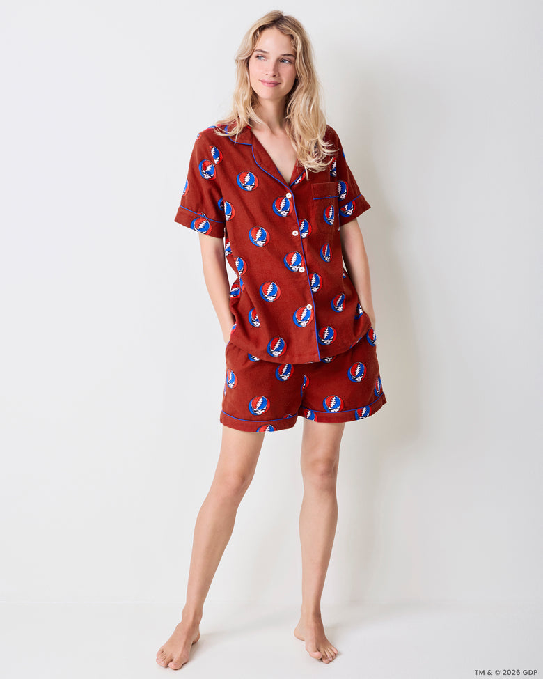 Front view of a red short-sleeve pajama set with a blue, red, and white skull-and-lightning-bolt print.