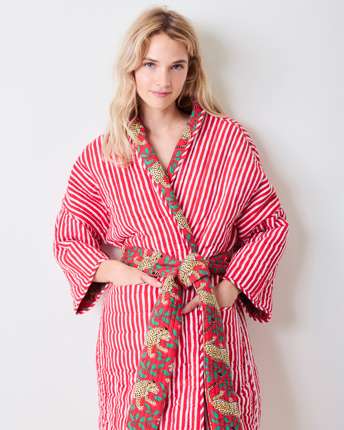 Front view of the striped side of a reversible quilted robe, with leopard-print trim and matching belt.