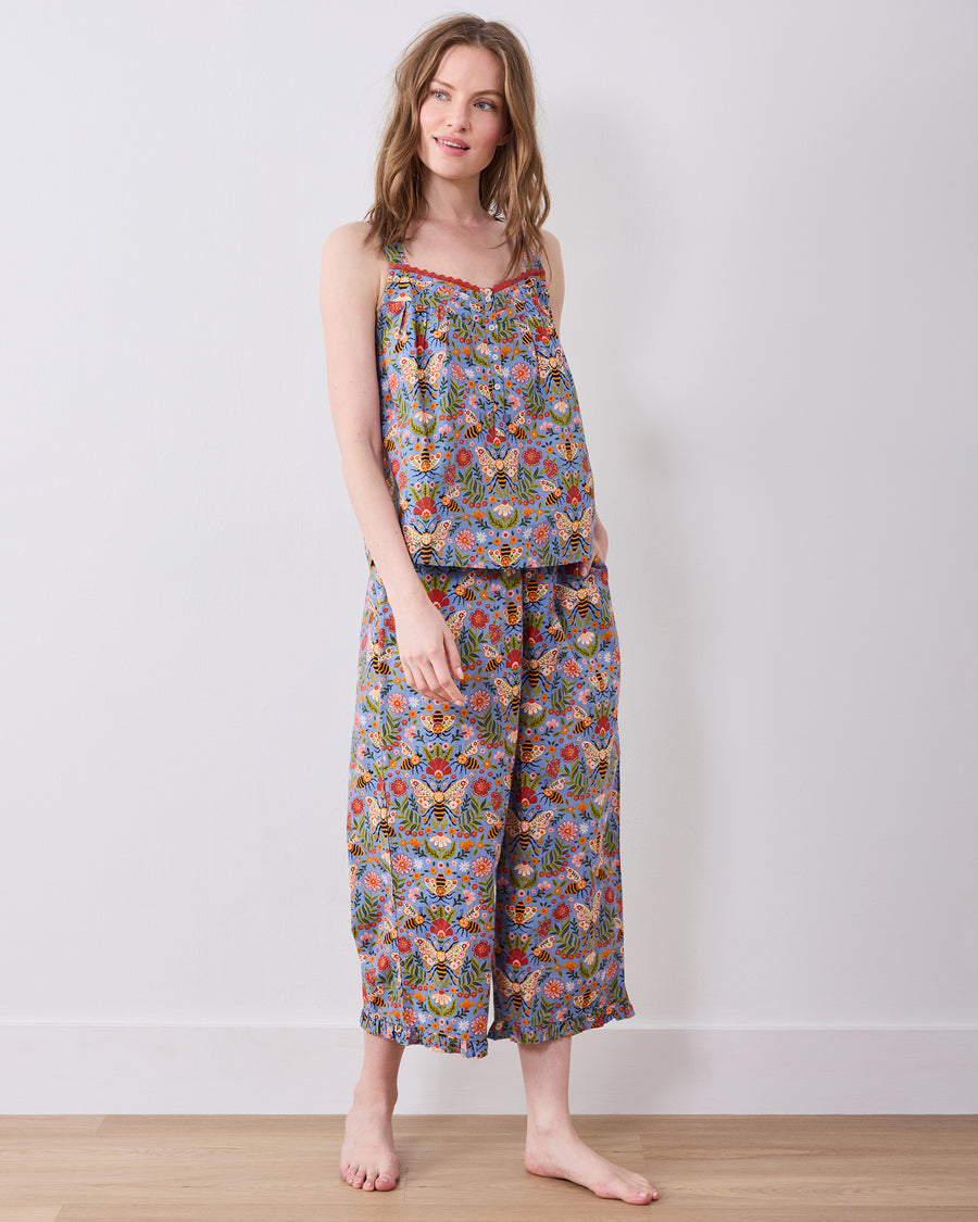Full-length front view of a sleeveless top and wide-leg cropped pajama pants with a blue bee-and-floral print.