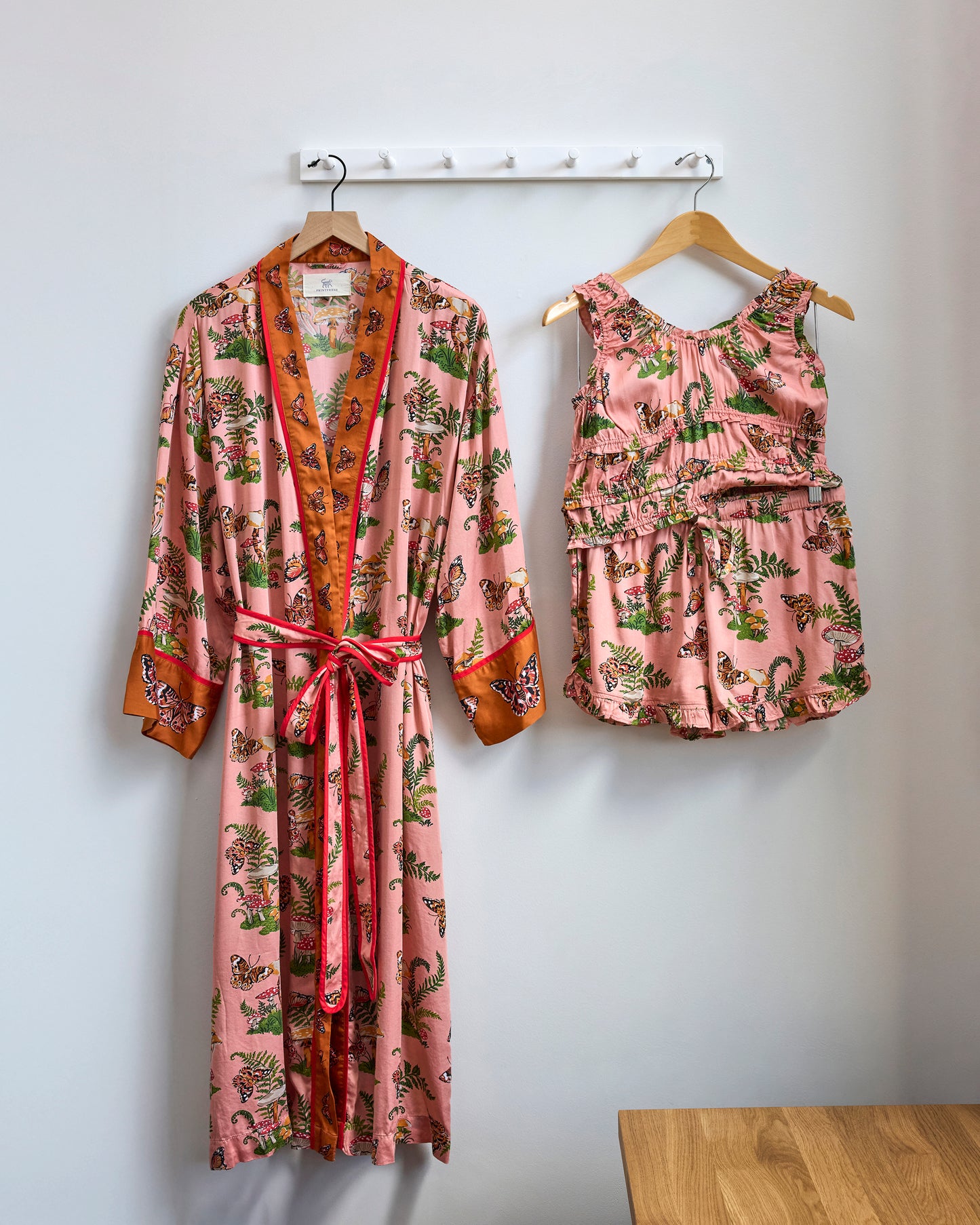Butterfly Forager printed robe and ruffle-trimmed short set hanging side by side.