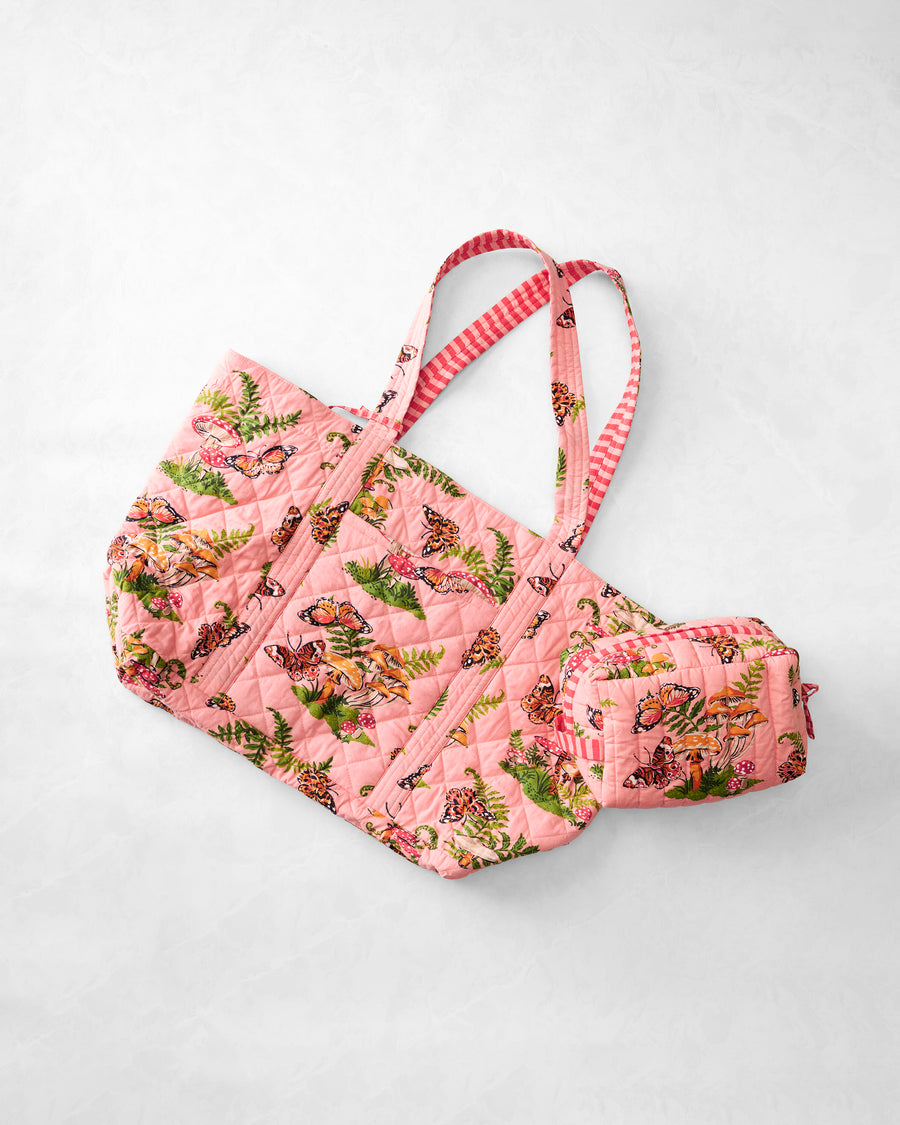 Pink quilted Butterfly Forager weekender tote and matching pouch arranged on a light background.