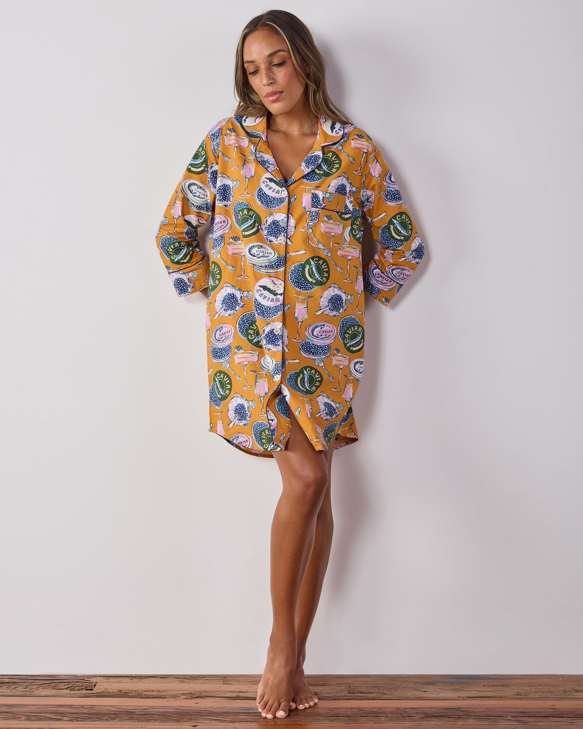 Full-length view of the goldenrod Champagne & Caviar button-down sleep shirt with a curved hem and three-quarter sleeves.