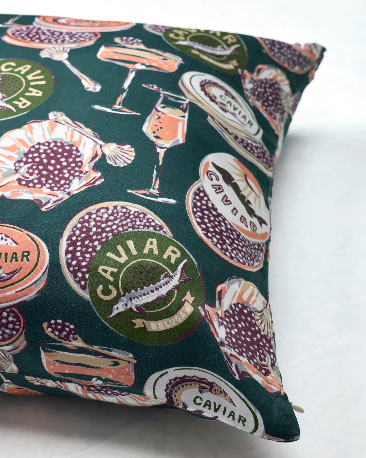 Close-up of a Peacock Feather Eco Satin pillowcase with a Champagne & Caviar print of caviar tins, champagne glasses, spoons, and fish.