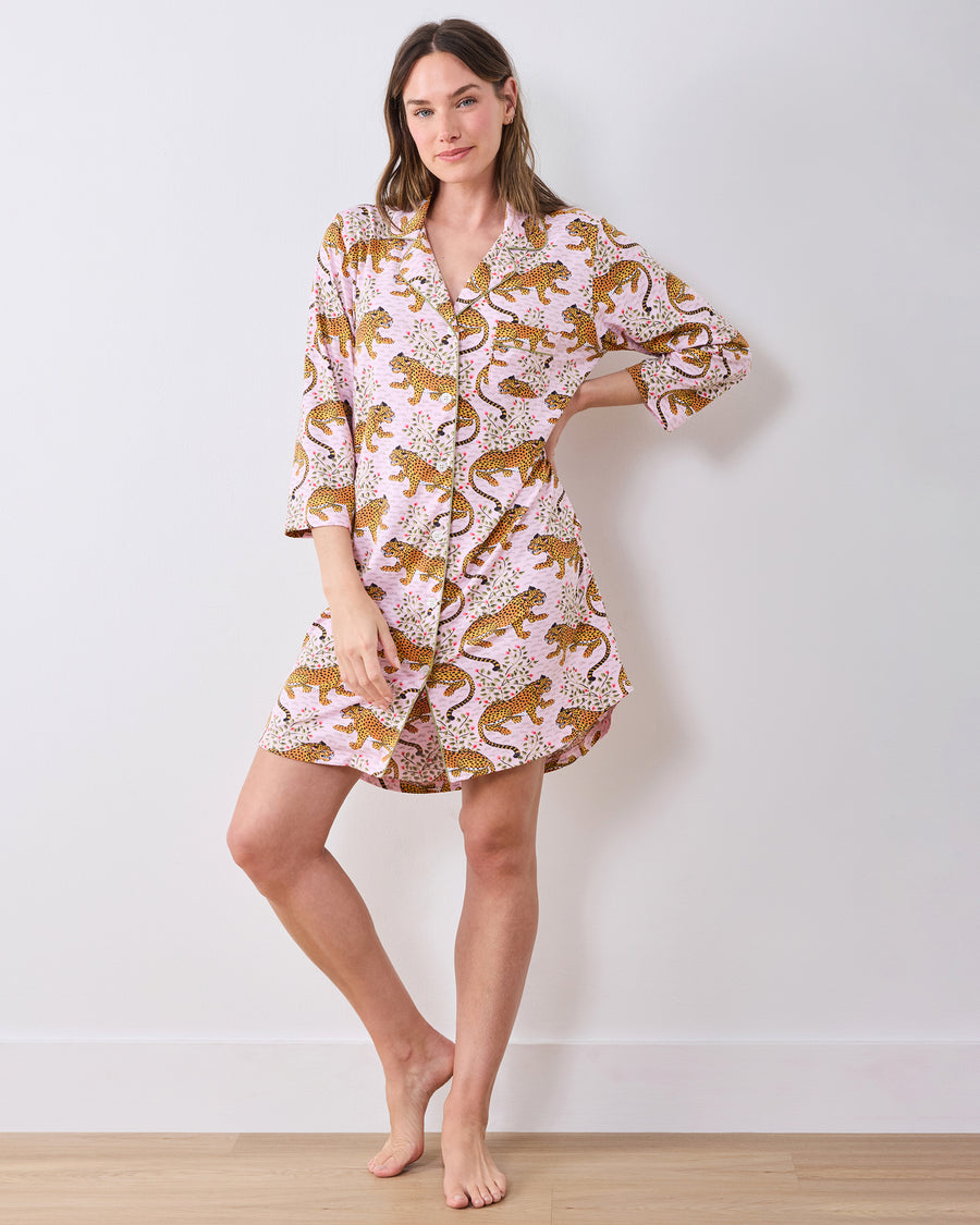 Full-length front view of a person wearing a pink leopard-and-floral print button-front sleep shirt with three-quarter sleeves.