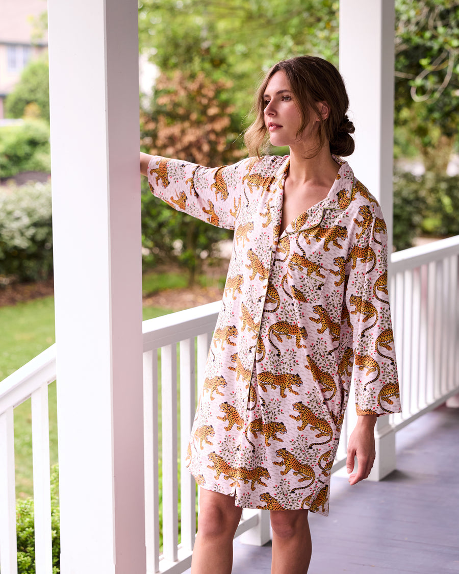 Blush Bagheera sleep shirt shown from the side, highlighting its collar, button front, long sleeves, pockets, and leopard print.