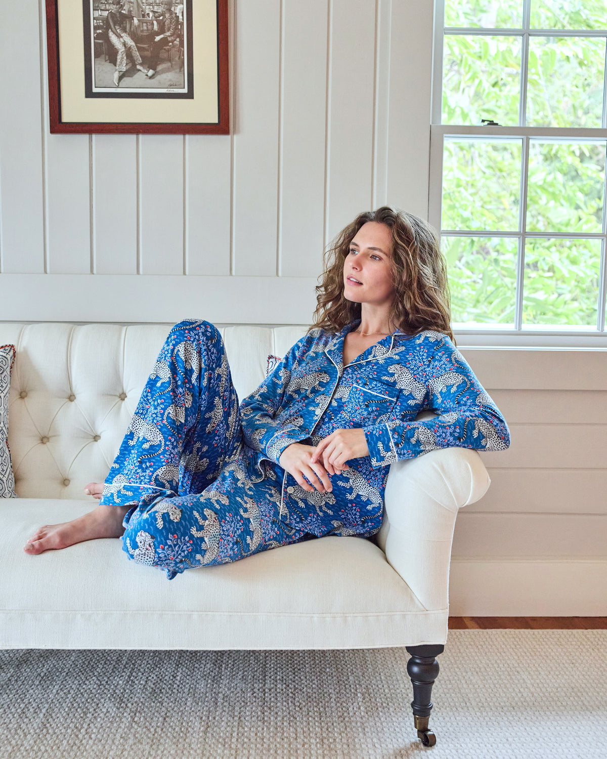 Model reclining on a sofa in the indigo Bagheera long pajama set