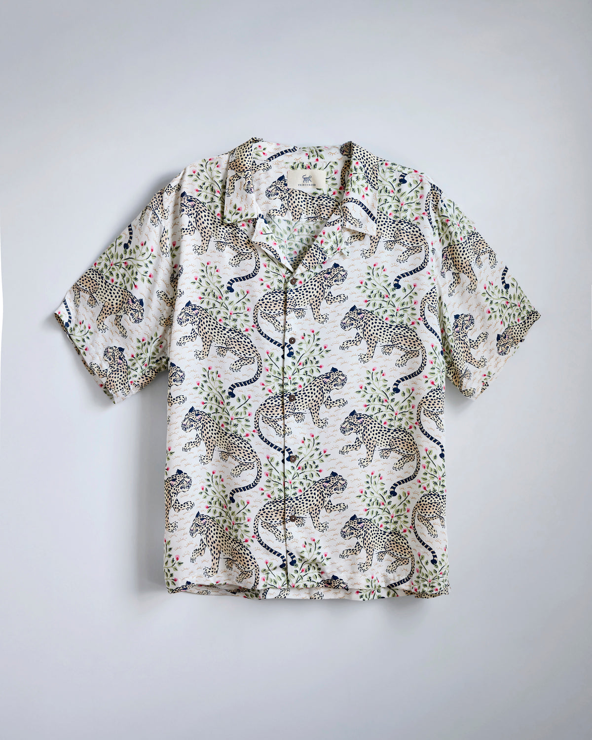 Flat-lay of the Wedding Cake Bagheera camp shirt with a leopard-and-floral print, open collar, short sleeves, and button front.