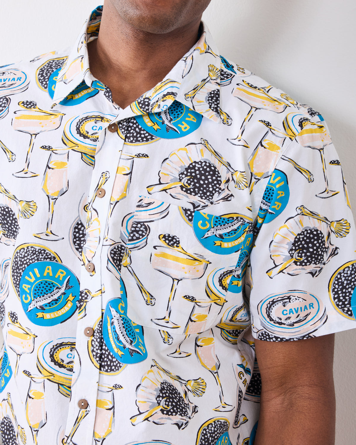 Close-up of the Champagne & Caviar Leo Shirt showing the collar, buttons, chest pocket, and caviar and champagne print.