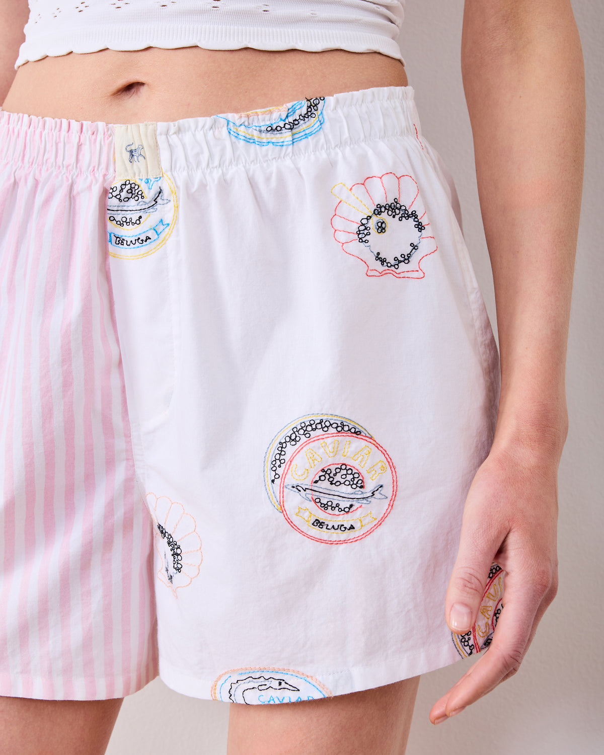 Close-up of the pearl boyfriend boxer shorts showing embroidered caviar tin and shell motifs.