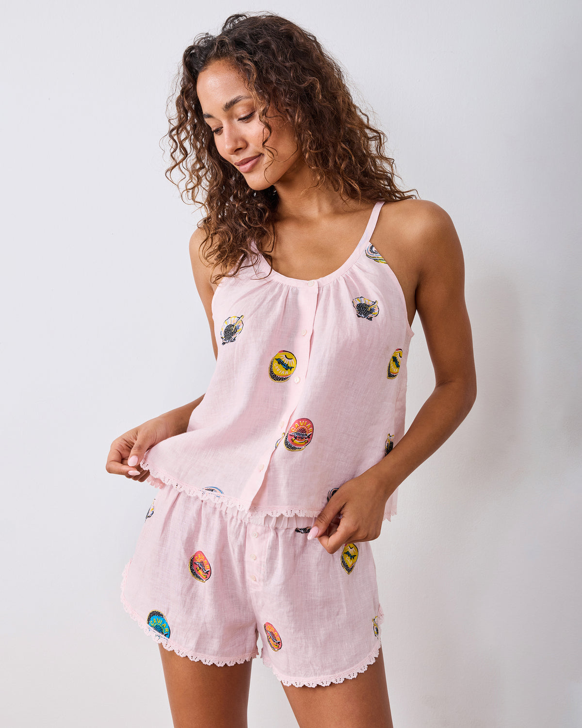 Studio view of the Pink Pearl linen cami and shorts set with embroidered caviar tin motifs and scalloped trim.