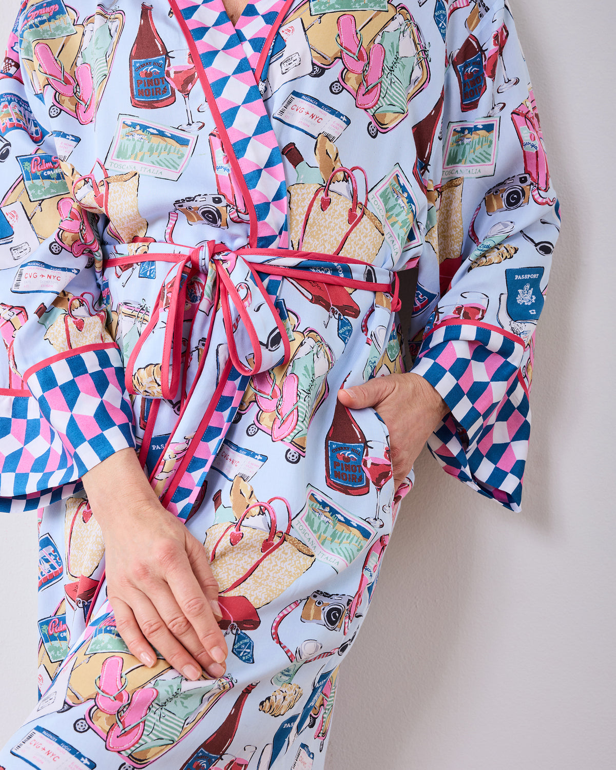 Close-up of the Emotional Baggage printed robe showing its waist ties, pocket, and travel-themed pattern.