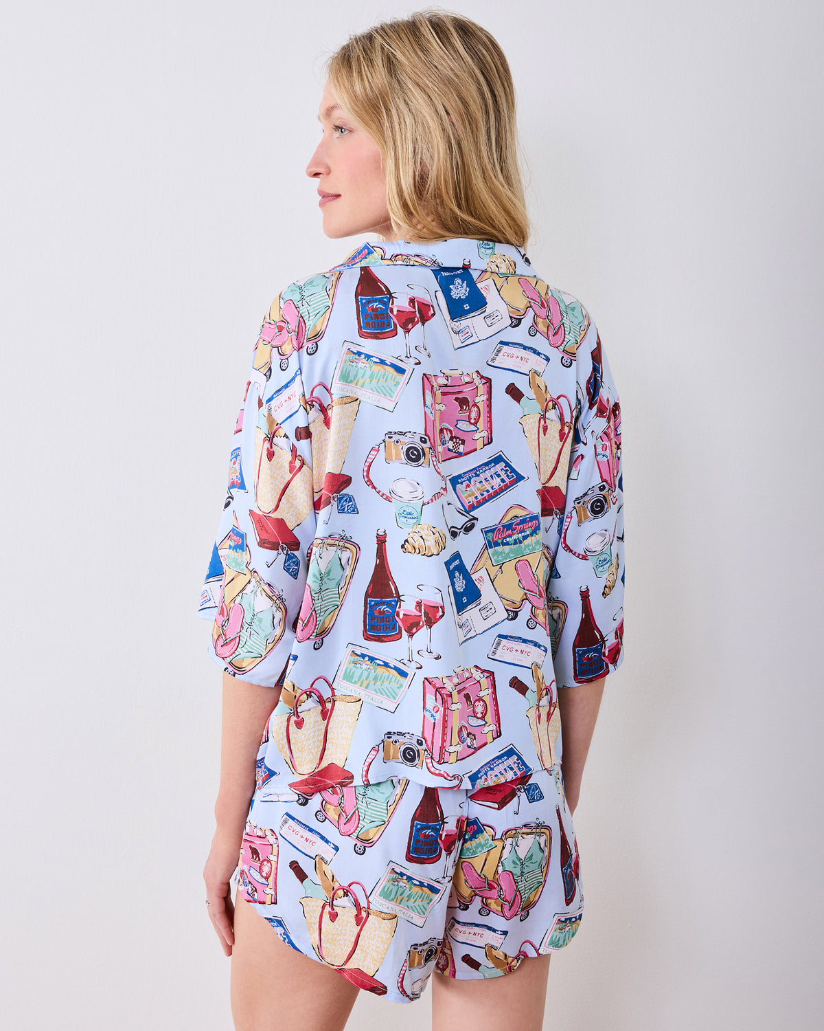 Back view of a person wearing a pale blue printed pajama top and matching shorts.