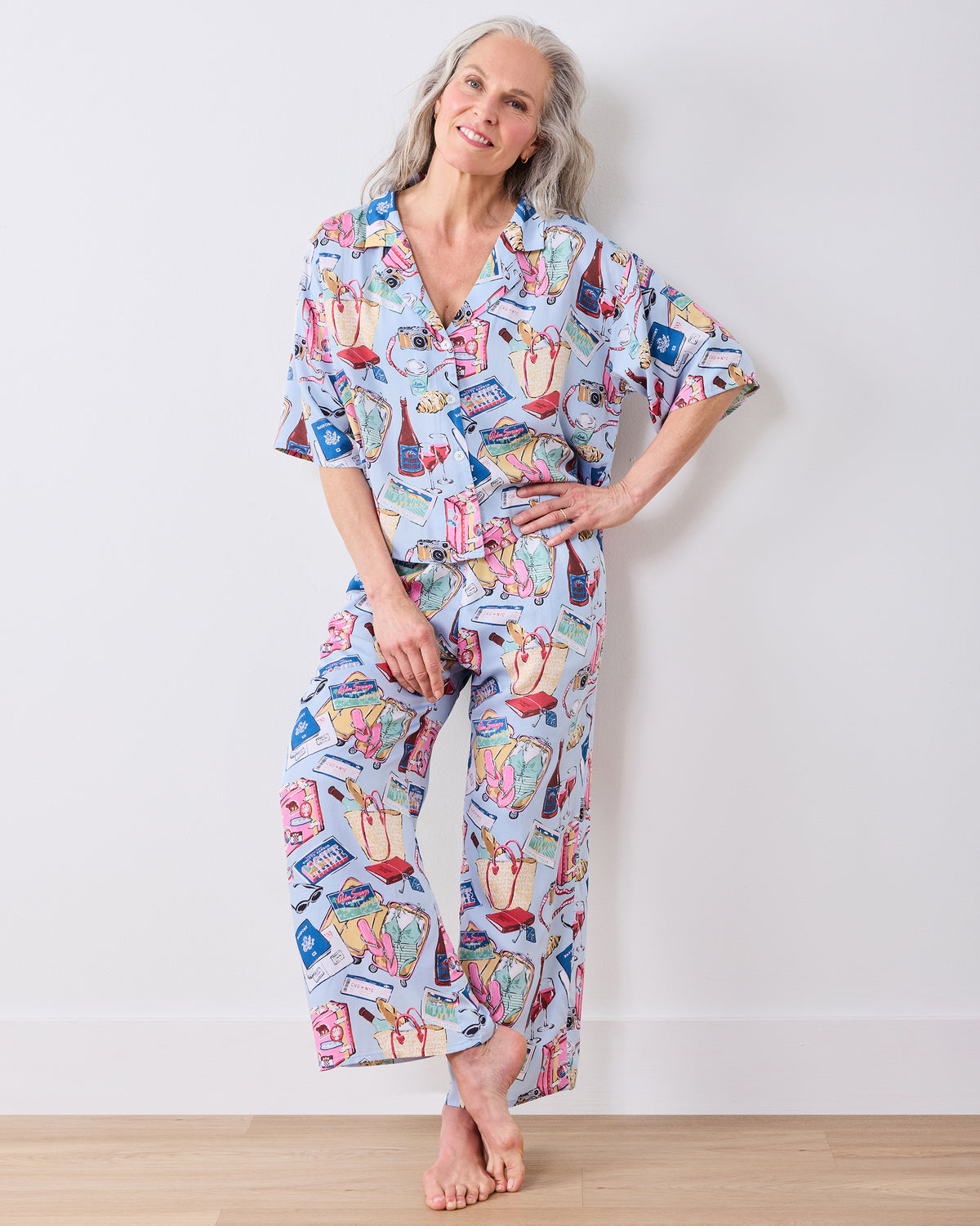 Full-length view of a person wearing a pale blue printed pajama set with a button-front top and wide-leg pants.