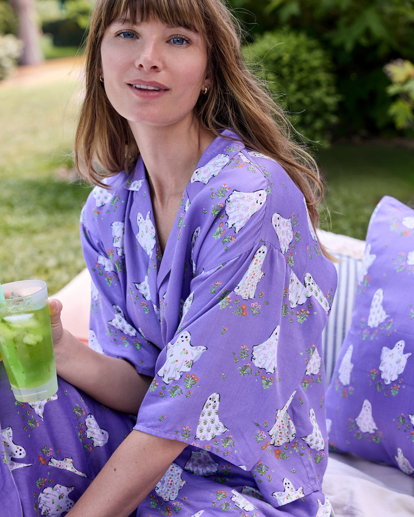 Person wearing the Gardening Ghosts pajama set with a purple ghost-and-floral print.
