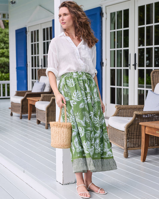 Three-quarter view of the olive green Devon Skirt with white heron and leaf print and striped hem