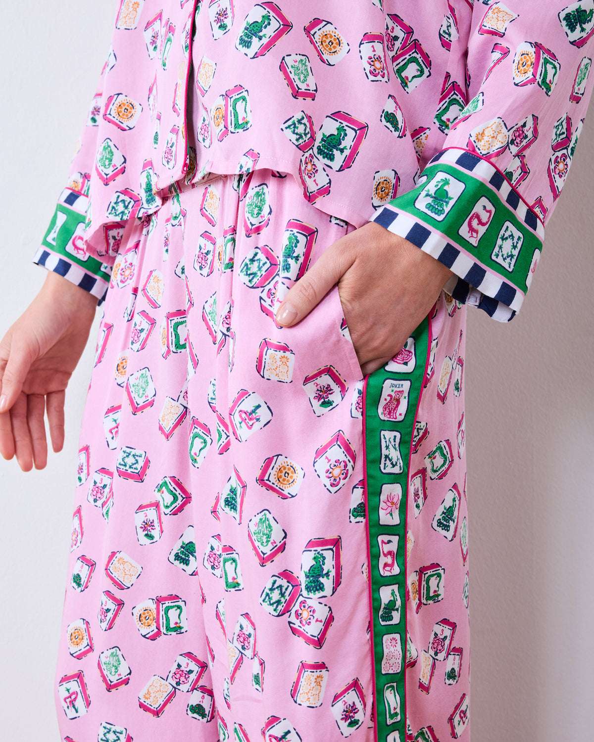 Close-up of the pink Lucky Tiles pajama set showing the patterned fabric, wide-leg pocket, and contrasting tile-print cuffs.