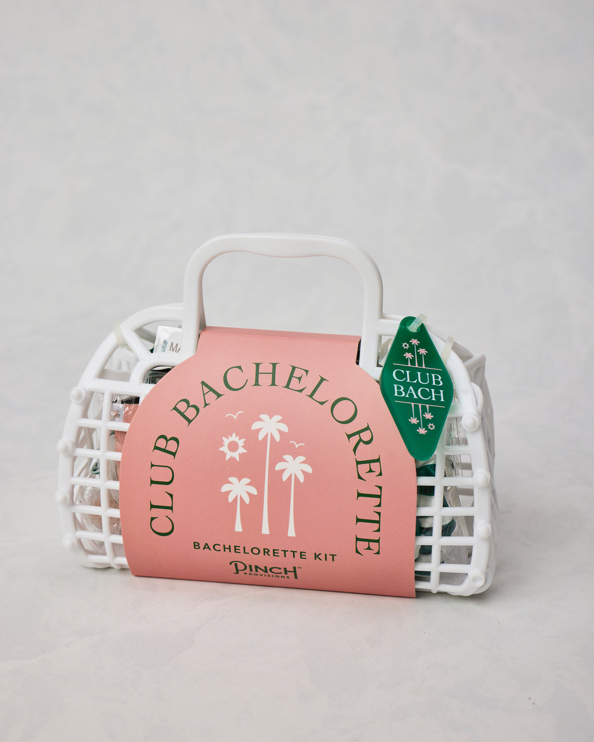White handled basket-style bachelorette kit package with a pink sleeve and green Club Bach tag.