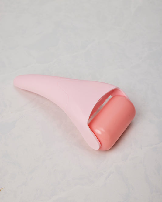 Pink ice roller shown from the roller-head side, with a rounded coral-colored roller and tapered handle.