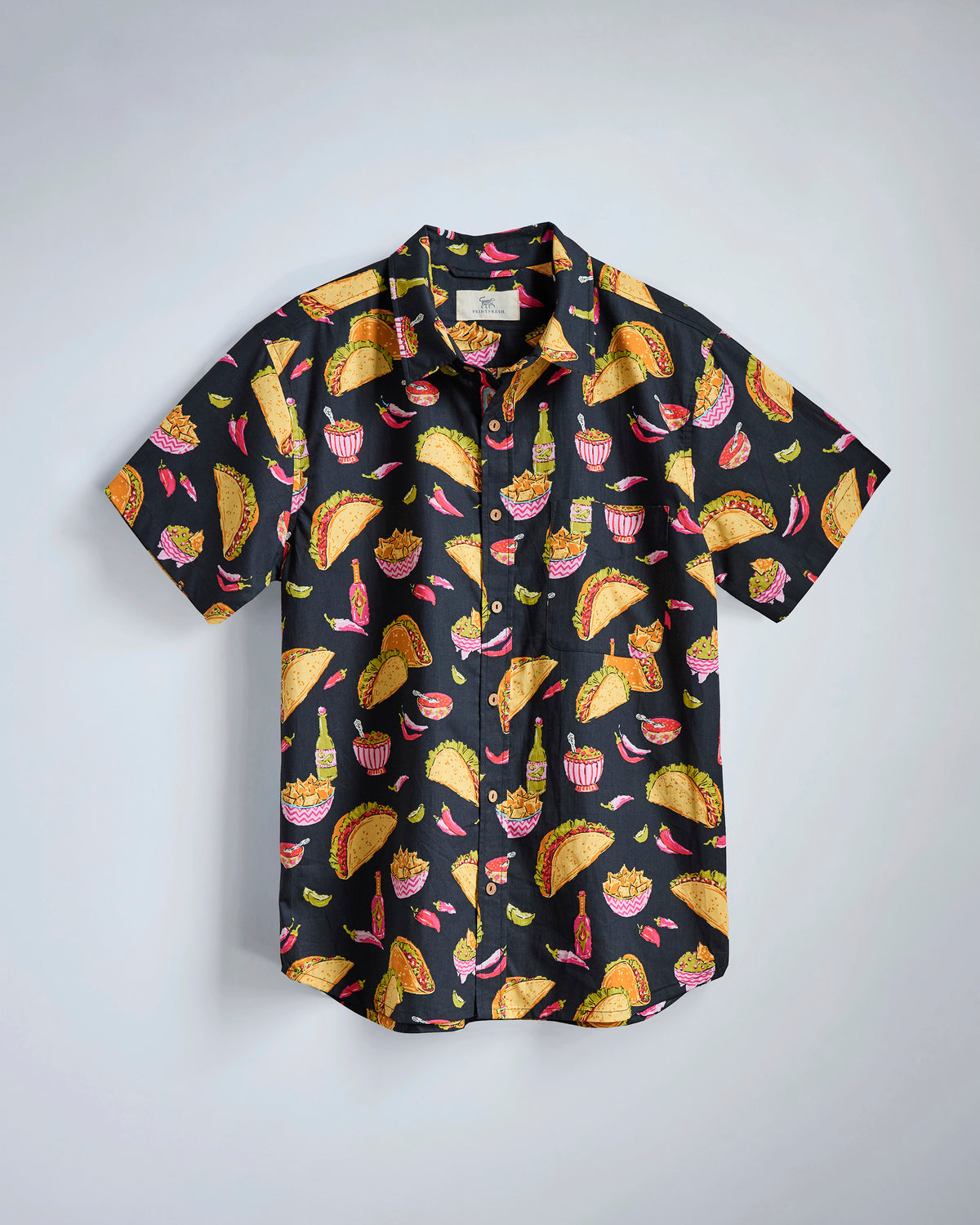 Black short-sleeve button-down shirt with a colorful repeating print of tacos, nachos, peppers, and bottles.