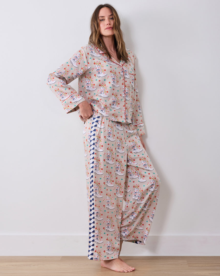 Full-length view of the matching long-sleeve, wide-leg pajama set posed against a wall, showing the printed pants and contrasting side panel.