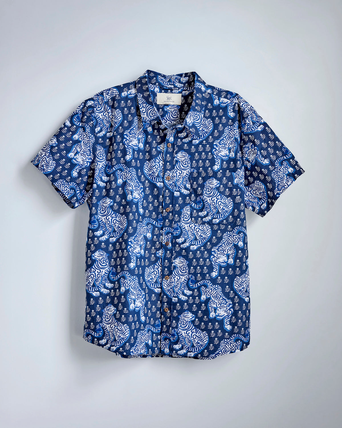 Flat-lay of the Indigo Tiger Queen Leo Shirt with a blue-and-white tiger print, short sleeves, collar, chest pocket, and button front.
