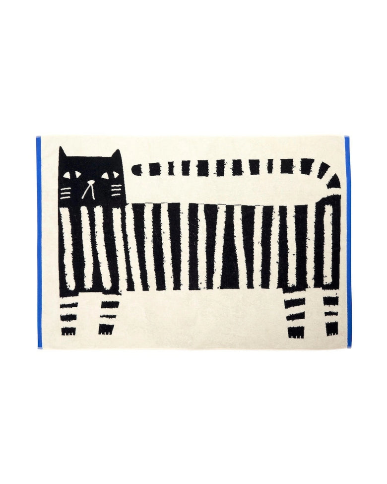 Flat-lay view of the Lazy Cat XL sheet towel, featuring a black cat and piano-key pattern on a light background.