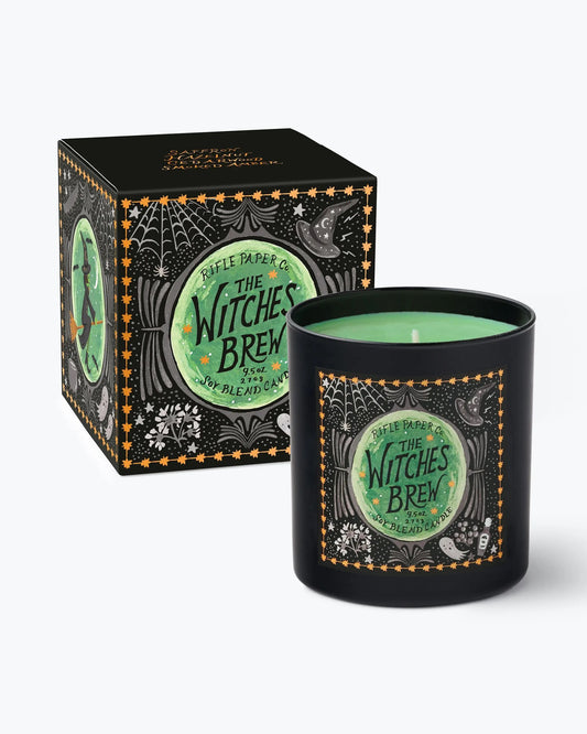Black Witches Brew candle with green wax shown beside its illustrated gift box.