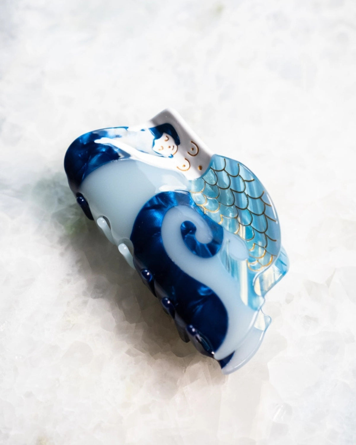 Blue and white mermaid-shaped hair clip shown at an angled front view